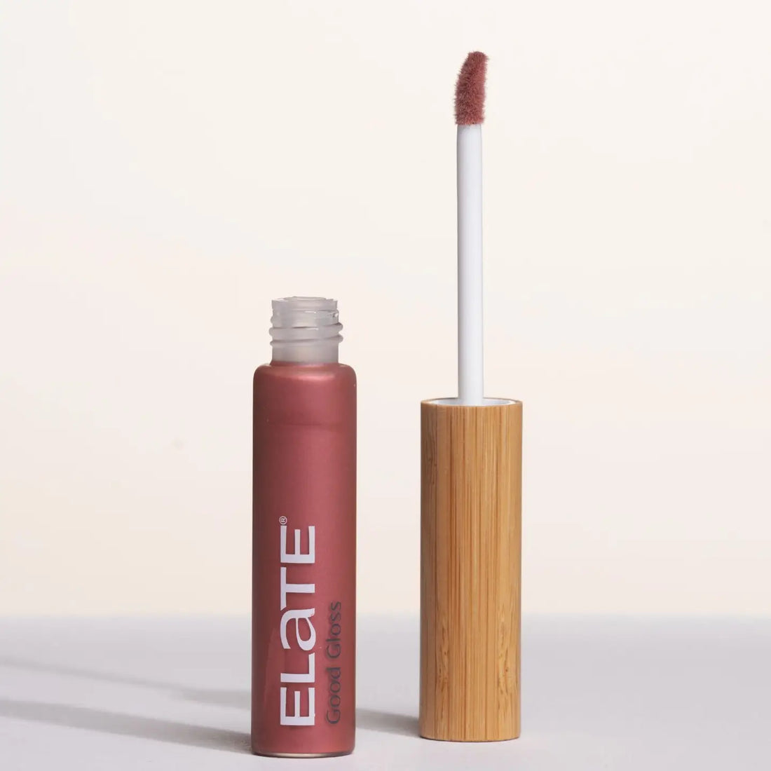 Elate gloss with wooden applicator on a light background