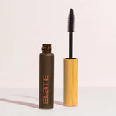 elate mascara glass container with bamboo wand next to it