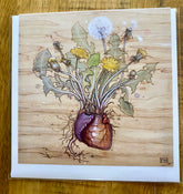 A detailed illustration of dandelions sprouting from a realistic heart, roots below, on wood-textured background—reminiscent of Fay Helfer’s style. Perfect as a unique gold foil art print on Artist Fay Helfer Greeting Cards by Fay Helfer.