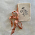 Small notebook with floral design and ribbon on a textured surface