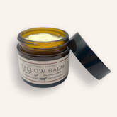 Tallow balm jar with open lid on a white background