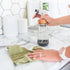 spray bottle with hands cleaning with a green towel