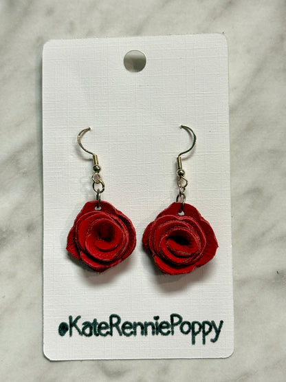 Red rose-shaped earrings on a white card with &