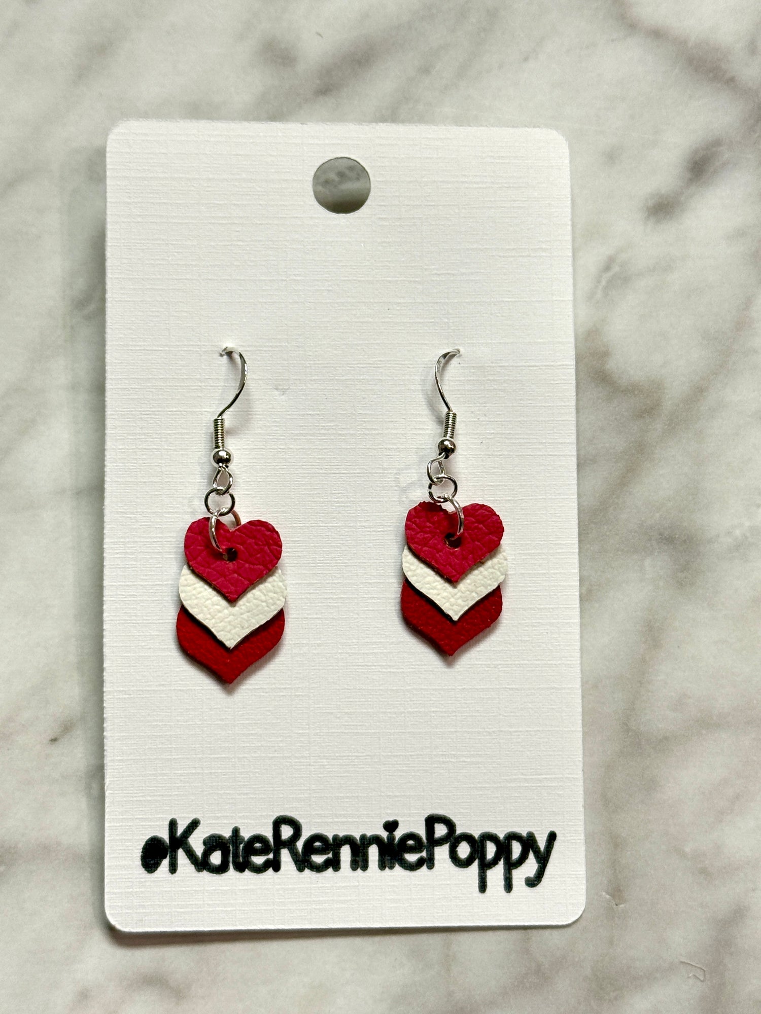 Heart-shaped earrings on a card with &