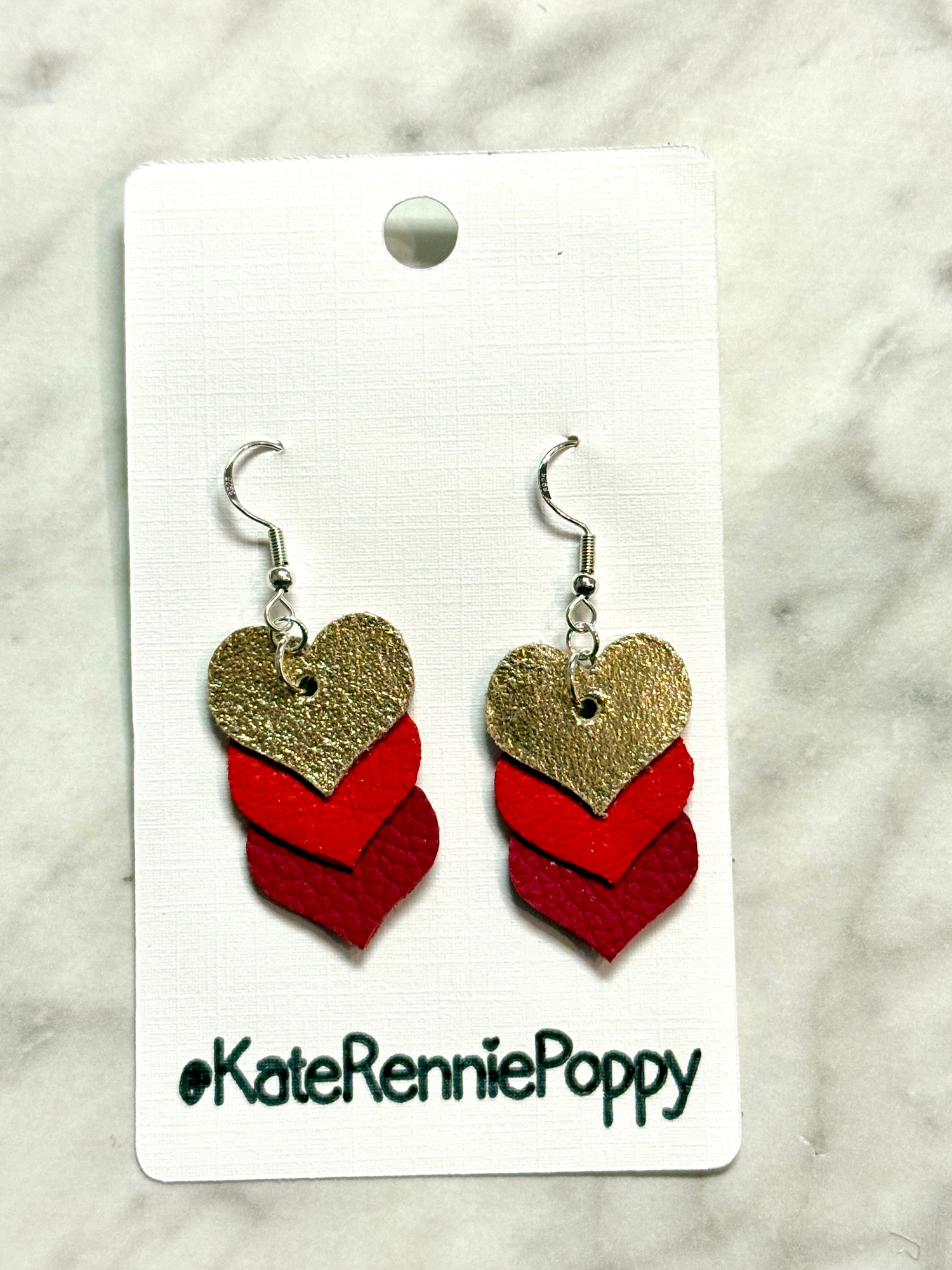 Heart-shaped earrings on a card with &