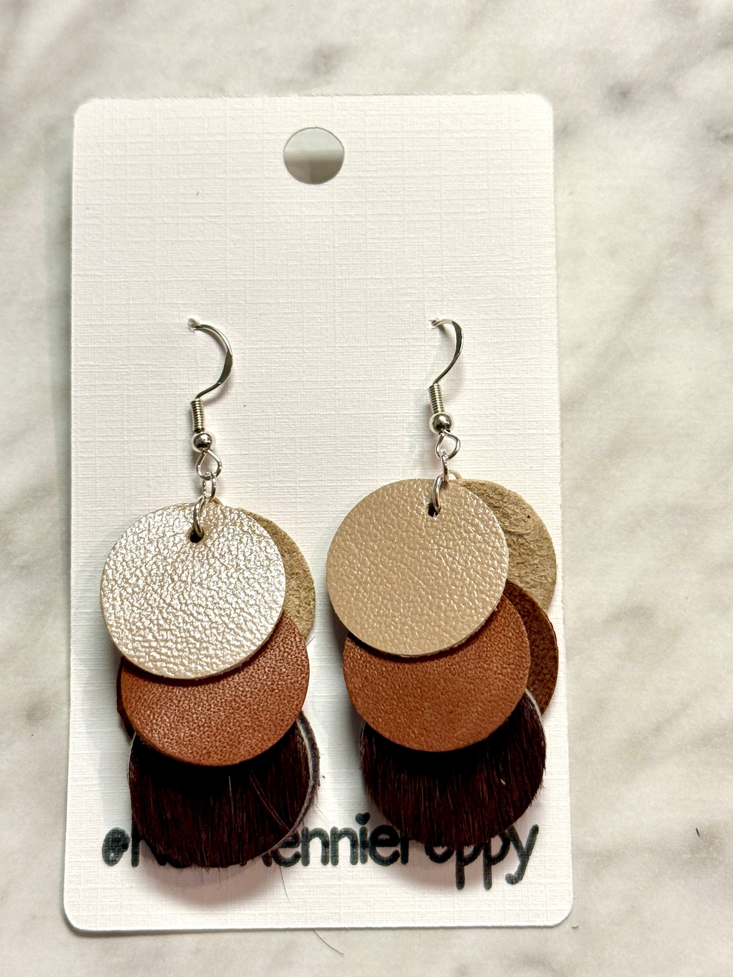 Pair of layered leather earrings on a card with &