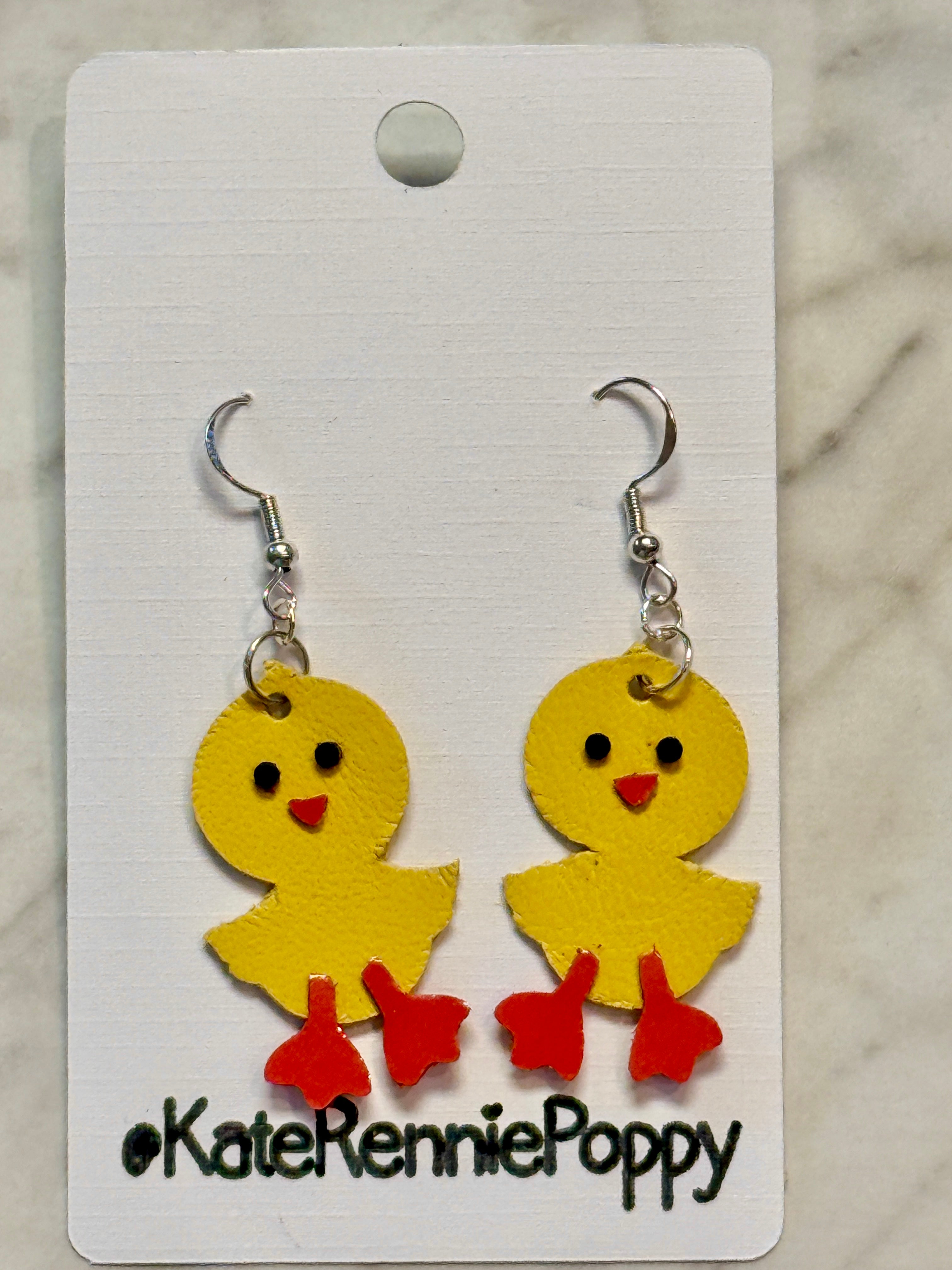 Yellow chick-shaped earrings on a card with &