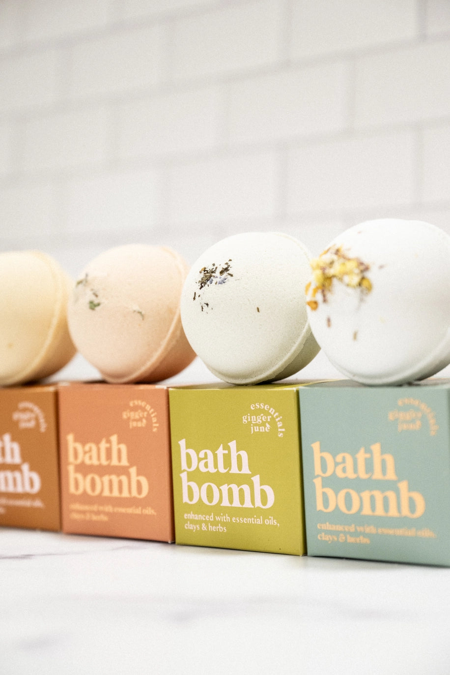 Four bath bombs with visible packaging on a light background