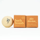 Bath bomb next to its packaging with &