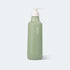 Green bottle with pump dispenser on a light gray background