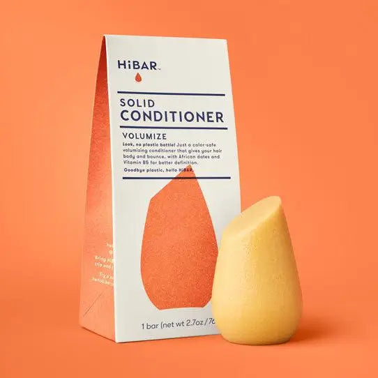 Solid conditioner bar and packaging on an orange background