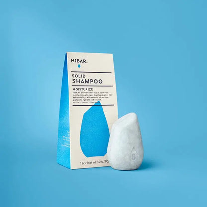 Solid shampoo bar and packaging on a blue background