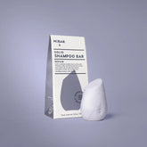 Solid shampoo bar with packaging on a gray background