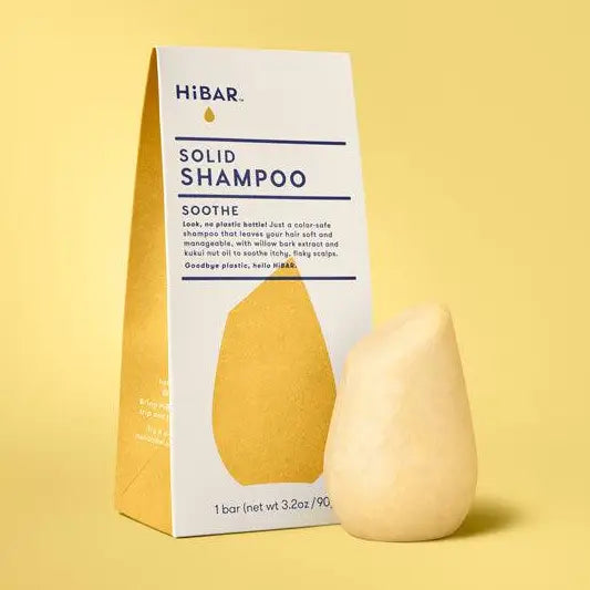 Solid shampoo bar with packaging on a yellow background