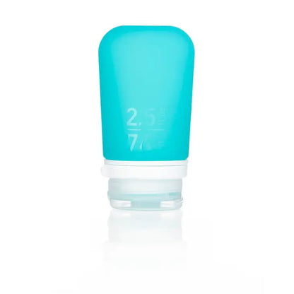 The Humangear GoToob+ is a small blue 2.5 fl oz (74 ml) refillable silicone travel bottle with a white flip-top cap, featuring a leak-proof design ideal for packing essentials.