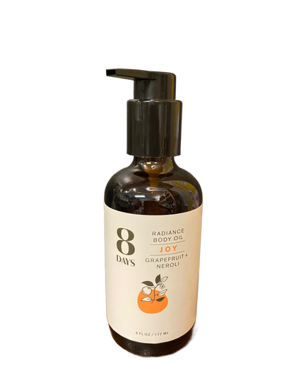 A dark brown pump bottle labeled 8 Days Botanicals Body Oil, Joy scent with grapefruit and neroli, displays two oranges on the front. This 6 fl oz (177 ml) body oil provides aromatherapy benefits.