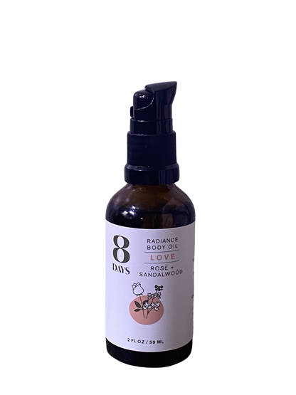 A 2 fl oz (59 ml) brown bottle of 8 Days Botanicals Body Oil in the "Love" scent, with rose and sandalwood, features a floral pink label, black pump dispenser, and offers aromatherapy benefits.
