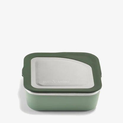 The Klean Kanteen Stainless Steel Lunch Box 23 oz is a square, green reusable food container with a stainless steel lid and dark green silicone trim, designed to be leakproof and shown against a plain white background.