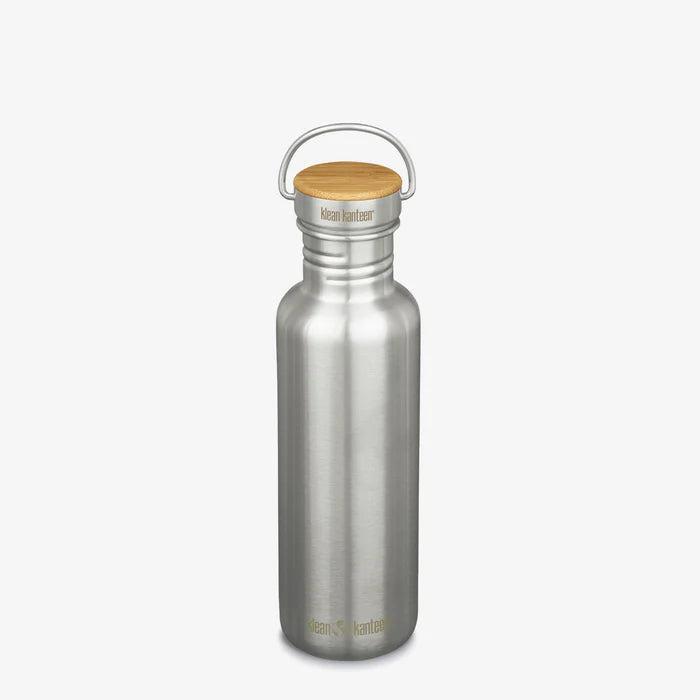 A minimalist, plastic-free Klean Kanteen Stainless Steel Water Bottle - 27 oz with a wooden cap and metal handle stands upright on a plain white background, showing the brand name near the bottom and on the lid.