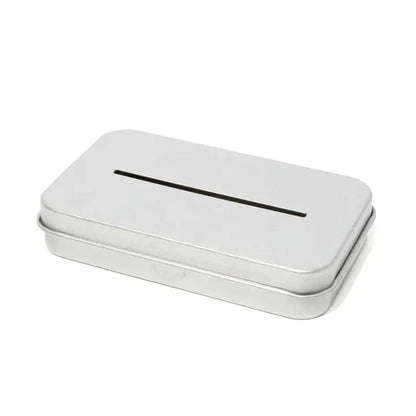The Leaf Razor Accessories by Leaf is a rectangular silver tin with a narrow slot on top, perfect for safely disposing of single edge razor blades—resembles a small donation box and keeps blade disposal secure.