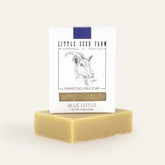 blue lotus soap in white box on top of bar of goat milk soap