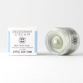 A jar of Little Seed Farm Deodorant Cream is open beside its white and blue box with black text. The aluminum-free cream inside is light green. Brand: Little Seed Farm.