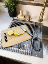 Kitchen sink with a cutting board, knife, and sliced lemons on a countertop.