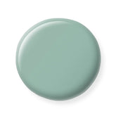 Round greenish nail polish sample  on a white background