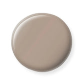 Round beige nail polish sample on a white background