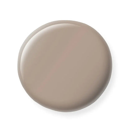 Round beige nail polish sample on a white background
