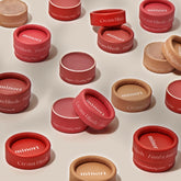 Minori Mini Cream Blush and Highlighter containers in assorted shades are spread across a light surface. Their packaging highlights "Vegan," "Cruelty-free," and the Minori brand, emphasizing sustainable beauty values.