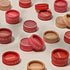Minori Mini Cream Blush and Highlighter containers in assorted shades are spread across a light surface. Their packaging highlights "Vegan," "Cruelty-free," and the Minori brand, emphasizing sustainable beauty values.