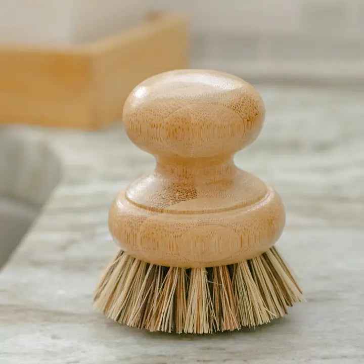 Wooden dish brush with bristle head on a marble surface