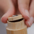 Close-up of a hand holding a bamboo floss case