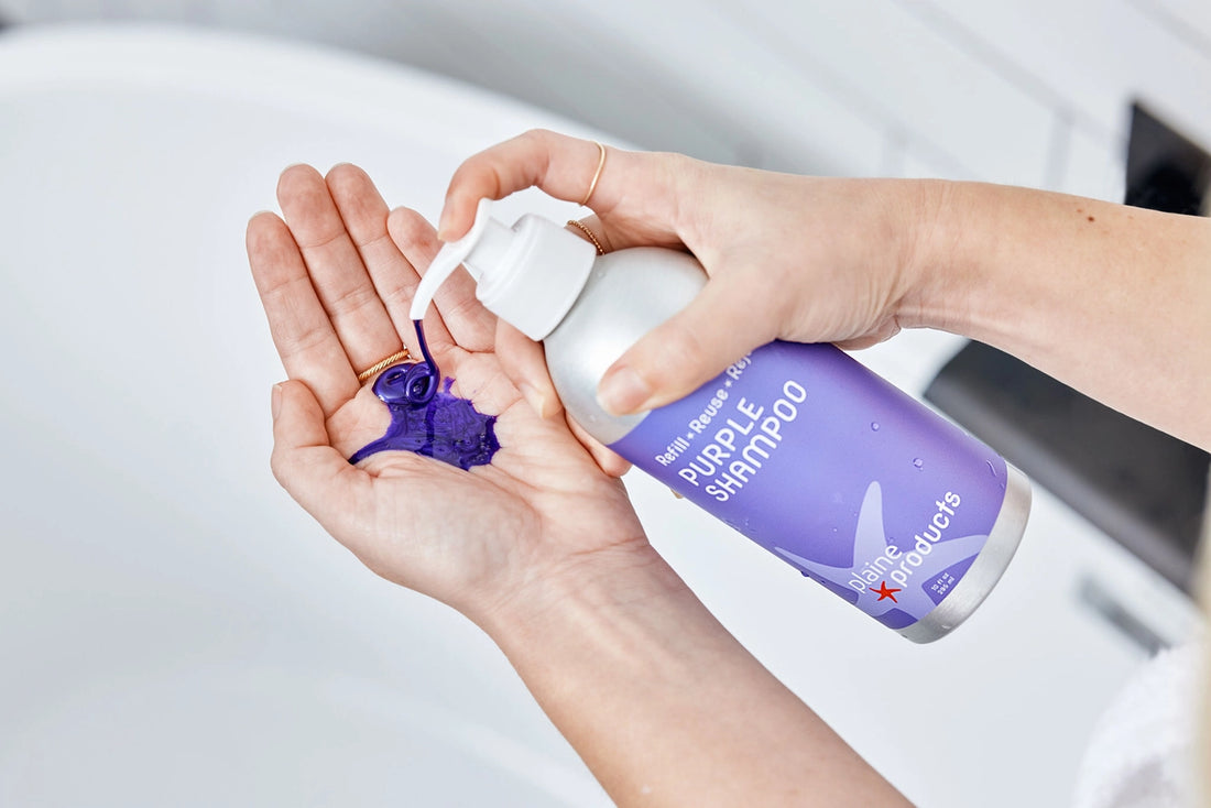 hands pumping purple shampoo