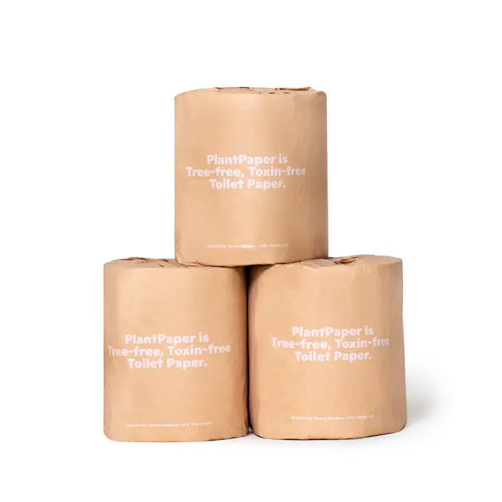 Three rolls of Plant Paper Toilet Paper by Plant Paper, wrapped in brown paper labeled "Tree-free, Toxin-free Toilet Paper," are stacked in a pyramid on a white background.