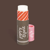 Lip balm with red and white striped cap on a brown background