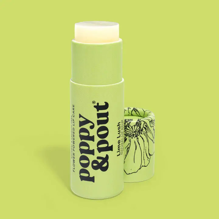 A pale green tube of Poppy &amp; Pout Lip Balm from Poppy &amp; Pout sits open with its floral-illustrated cap nearby, all displayed against a coordinating green background.