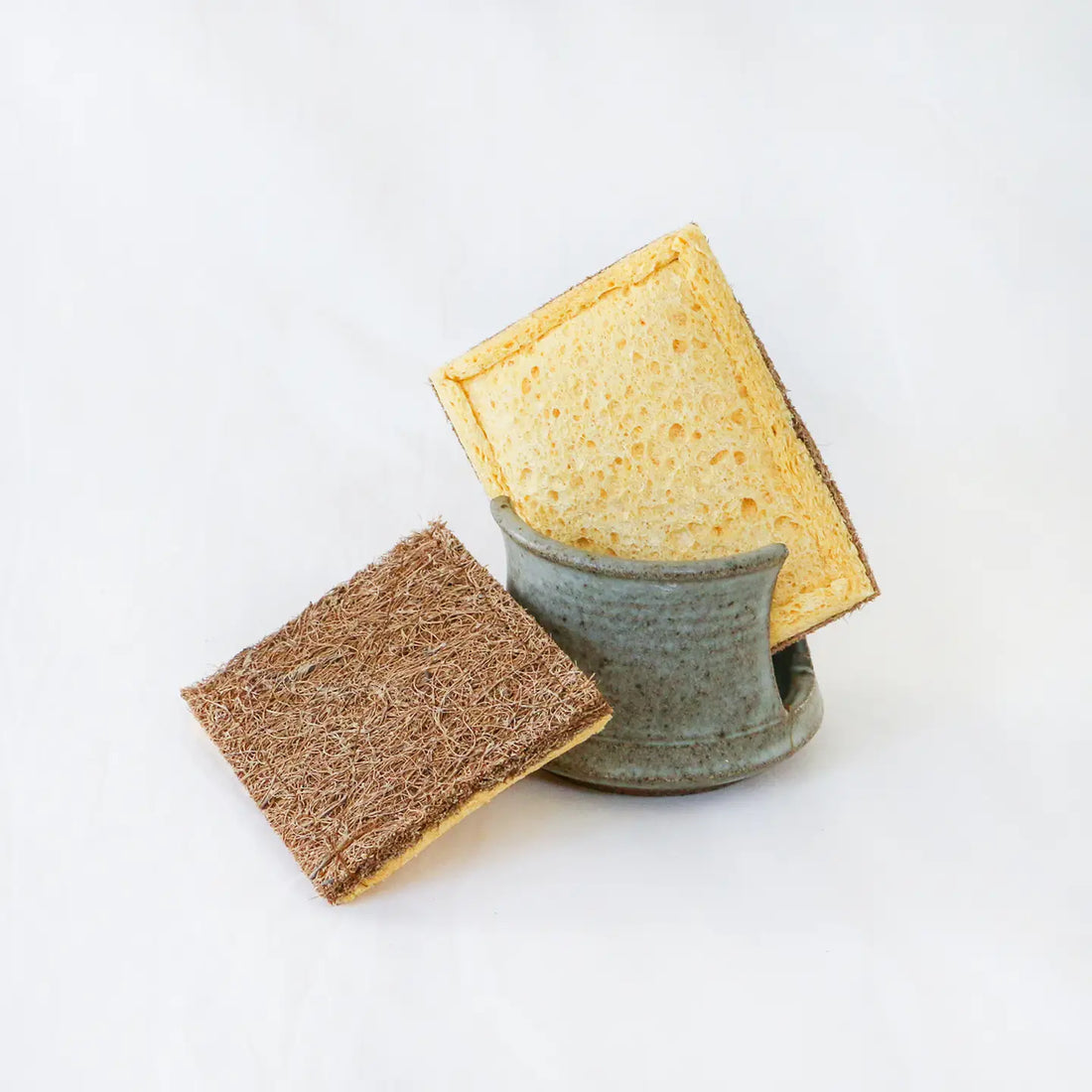 yellow sponge with coconut fibers on the other side in a ceramic dish
