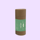 brown cardboard container with green label for hair wax