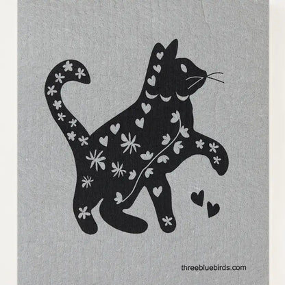 The Cats and Dogs Swedish Dishcloth by Three Bluebirds Swedish Dishcloths features a black cat silhouette with white hearts and flowers on a light gray background. Biodegradable &amp; eco-friendly.