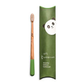 The Truthbrush - Bamboo Toothbrush, with compostable bamboo handle and green bristles, rests next to its green panda-illustrated box labeled "tiny truthbrush beautiful bamboo toothbrush" by Truthbrush.
