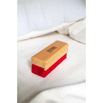 Red and wooden brush on a white textured surface