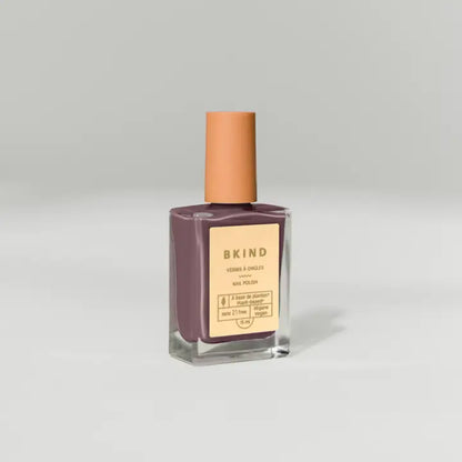 A bottle of BKind Nail Polish by BKind with a tan cap and mauve shade sits against a plain light gray background, featuring a beige label with product details.
