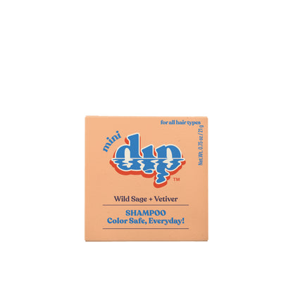 A peach square box of Dip Shampoo Bar (Wild Sage + Vetiver), 0.75 oz travel size, salon-grade, color-safe, and suitable for all hair types. Blue and white text design by Dip.