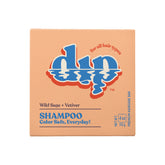 A square, peach-colored Dip Shampoo Bar box labeled for all hair types features the Wild Sage + Vetiver scent and "Color Safe, Everyday!" tagline. This salon-grade, 4 oz (113g) travel-size bar by Dip ensures premium haircare anywhere.