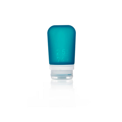 The Humangear GoToob+ is a small, blue, silicone 2.5 fl oz (74 ml) travel bottle with a clear flip-top cap. This refillable, leak-proof toiletry container stands upright on a white background.
