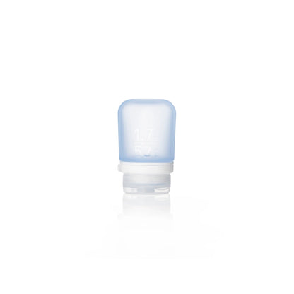 The Humangear GoToob+ is a small, translucent blue silicone travel bottle with a white flip-cap, standing upright. This refillable toiletry container has front measurement markings and is perfect as a leak-proof travel accessory.