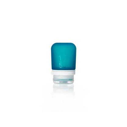 The Humangear GoToob+ is a small blue refillable silicone travel bottle with a clear white screw-on cap. It stands upright against a plain white background and features leak-proof construction with embossed measurement markings.