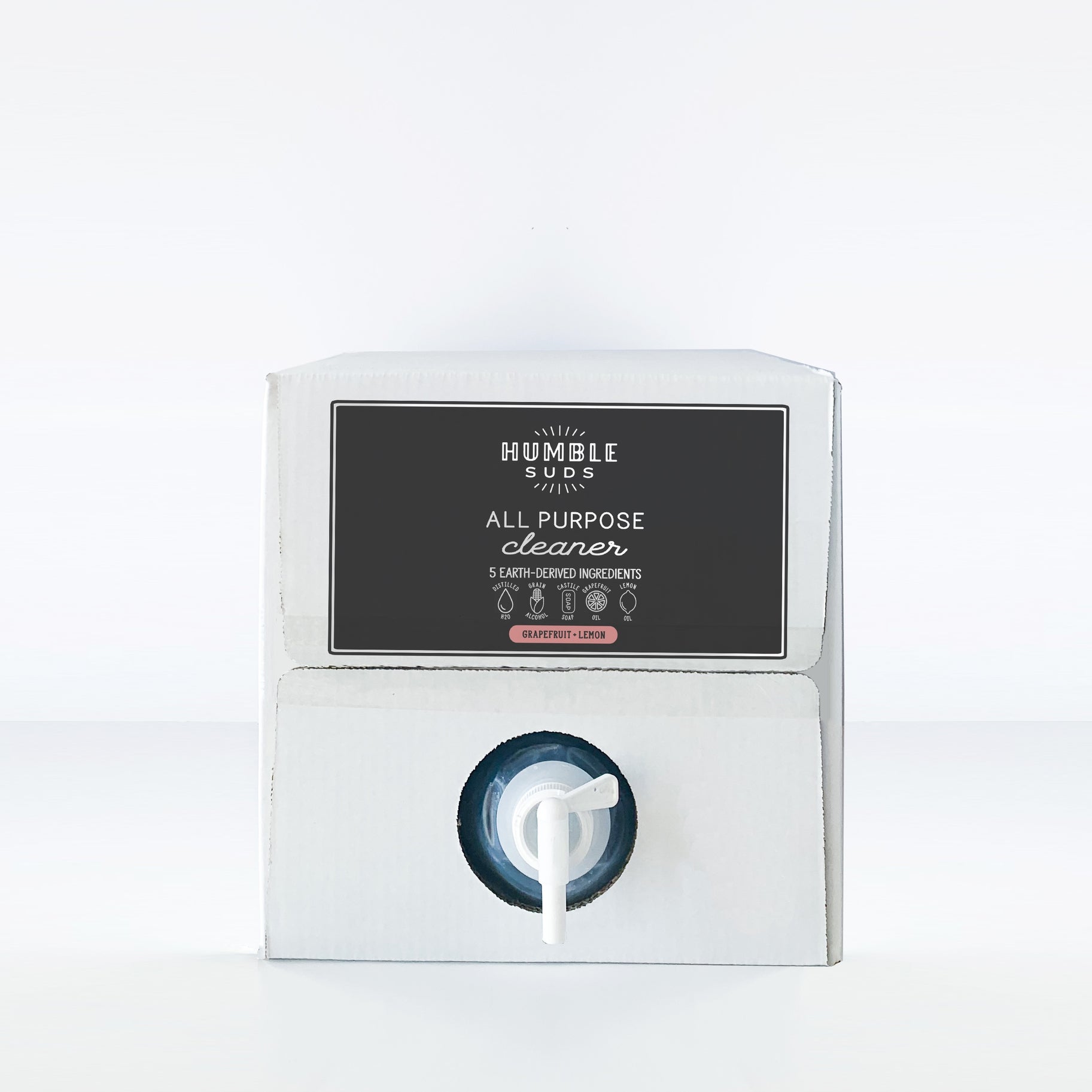 A white box with a black "Humble Suds Bulk All Purpose Cleaner" label and bottom spout for easy dispensing. This plant-based cleaner offers a refreshing grapefruit and lemon scent.